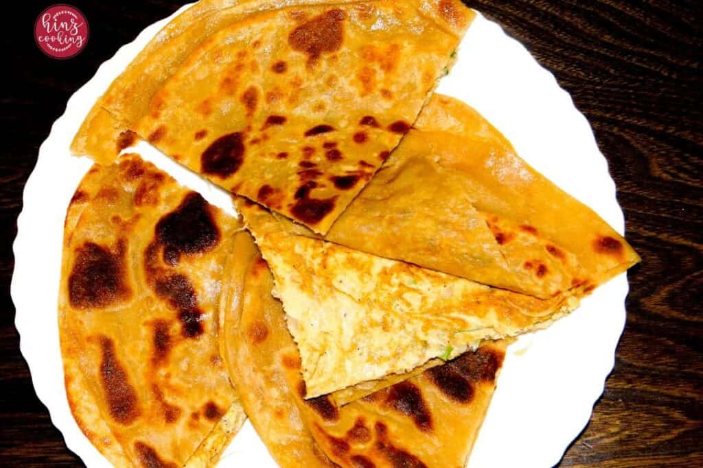 Partha cut into 4 pieces, Showing the layer of paratha with egg.