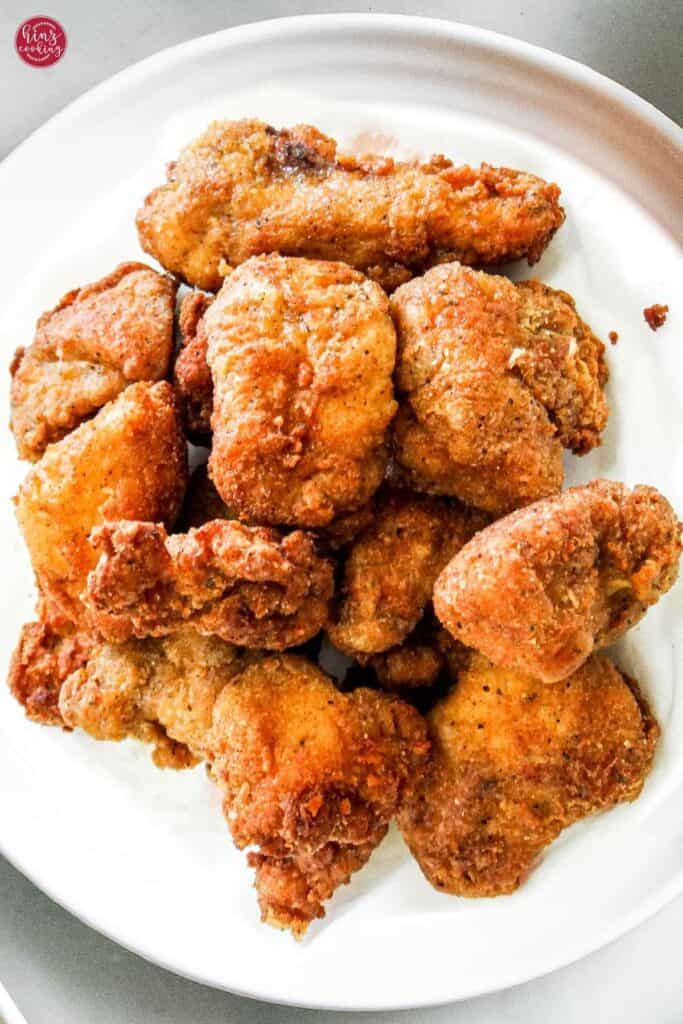 spicy popcorn chicken pieces on a white plate.