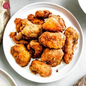 crispy and crunchy chicken popcorn pieces in a white plate.