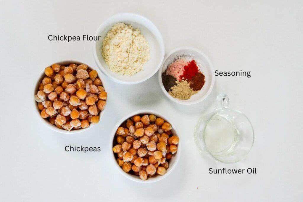 roasted chickpeas air fryer ingredients (chickpeas, corn flour, seasoning, oil) displayed on white board.