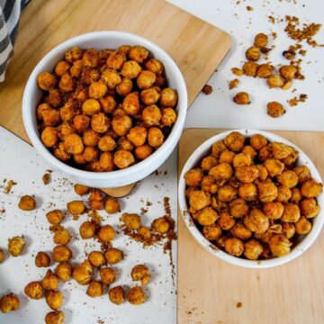 Air fryer roasted chickpeas in two white bowls on a white table, emphasizing their extremely crispy and crunchy texture.